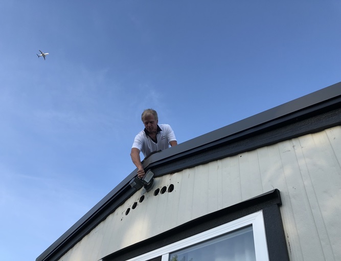 inspecting-the-roof-with-tools Man inspecting the roof